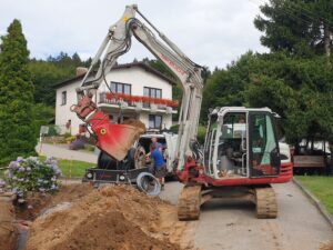 Bagr Takeuchi při bagrování v obci